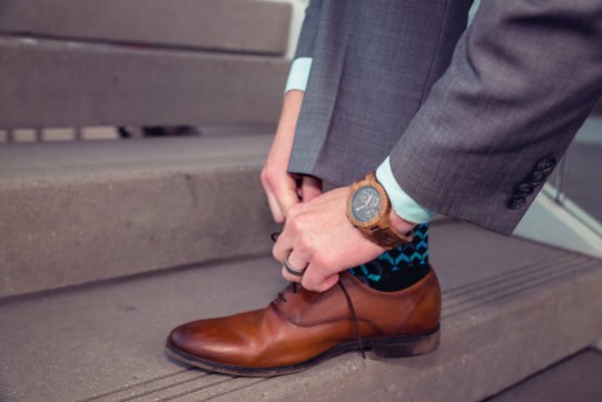 man wearing jord conway series walnut jet black unique wood watch tying steve madden shoe laces